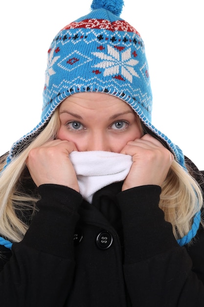 Giovane donna con un cappuccio che si congela in inverno