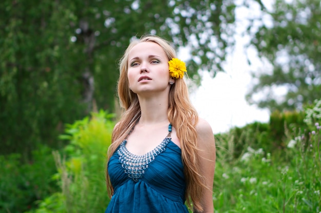 giovane donna con un fiore giallo tra i capelli