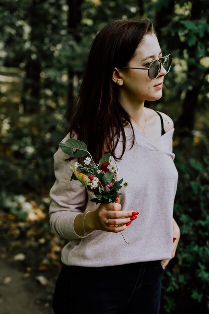 Giovane donna con un fiore in mano