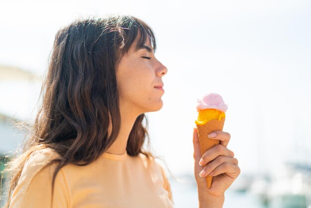 Giovane donna con un gelato di cornetta all'aperto