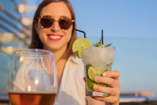 giovane donna con un mojito in un tetto.