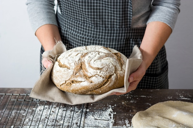 giovane donna con un pane rustico in mano