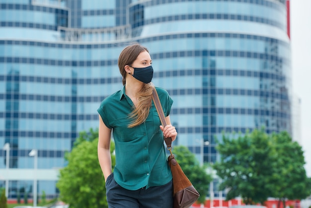 Giovane donna con una maschera nera in città