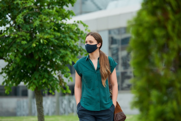 Giovane donna con una maschera nera in città