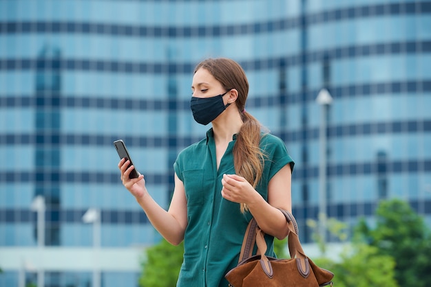 Giovane donna con una maschera nera in città