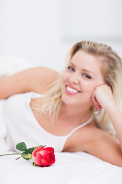 Giovane donna con una rosa sorridente