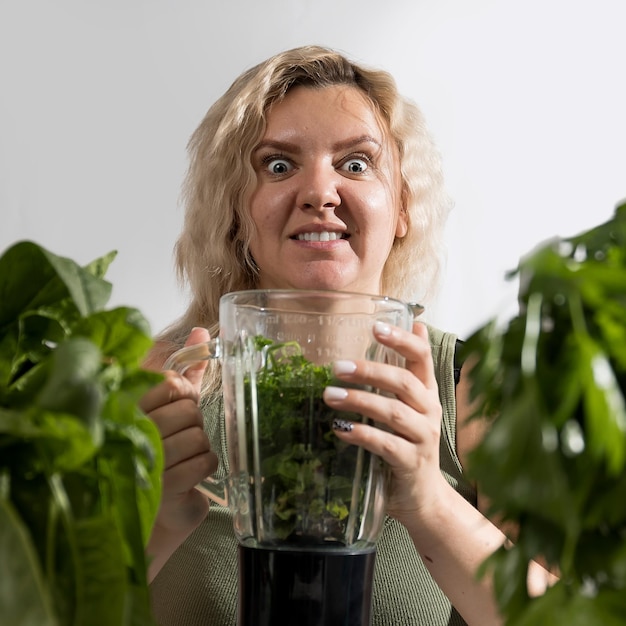 Giovane donna con una serie di ingredienti verdi lattuga spinaci per una dieta sana