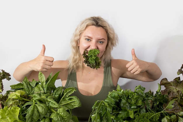 Giovane donna con una serie di ingredienti verdi lattuga spinaci per una dieta sana