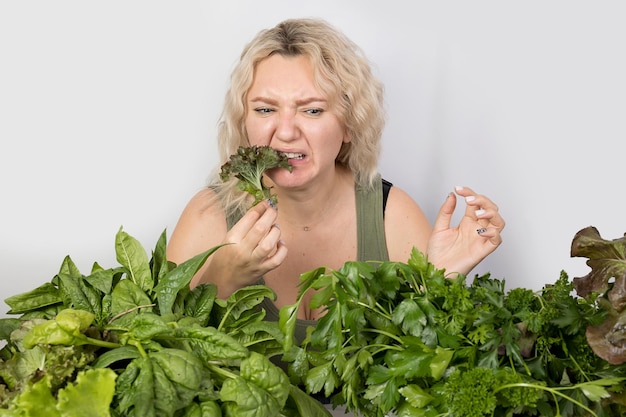 Giovane donna con una serie di ingredienti verdi lattuga spinaci per una dieta sana
