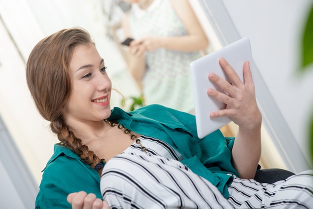 Giovane donna con una treccia utilizzando un tablet PC