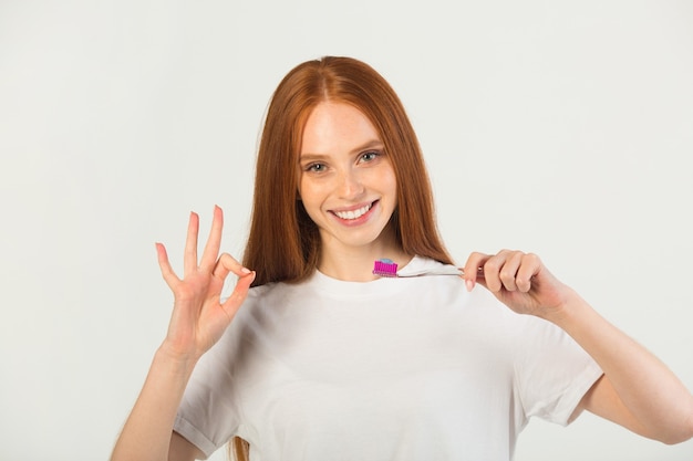 Giovane donna con uno spazzolino da denti in mano