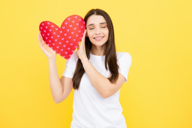 Giovane donna concetto di giorno di San Valentino ragazza con carta a forma di cuore Bella ragazza affascinante che tiene in mano