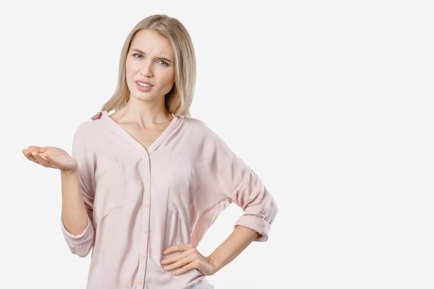 Giovane donna confusa in camicia in posa isolata su sfondo bianco