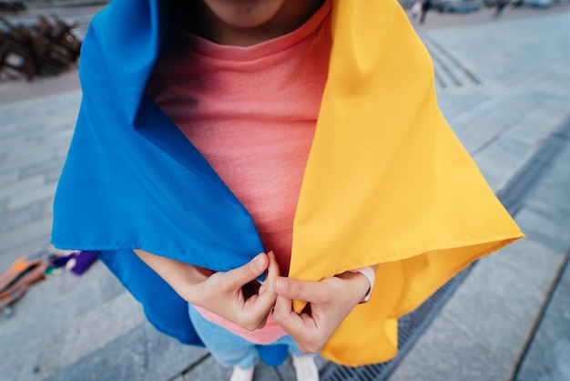 Giovane donna coperta con la bandiera ucraina