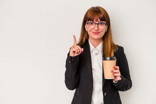 Giovane donna curvy caucasica di affari che tiene un caffè isolato su fondo bianco che mostra il numero uno con il dito.