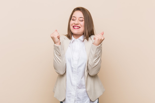 Giovane donna d'affari alzando il pugno, sentirsi felici e di successo. Concetto di vittoria.