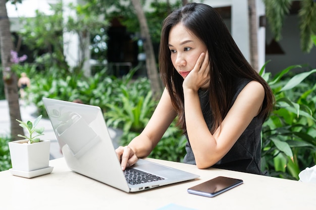 Giovane donna d'affari asiatica sta lavorando su un computer portatile Lavoro da casa concetto di business e tecnologia