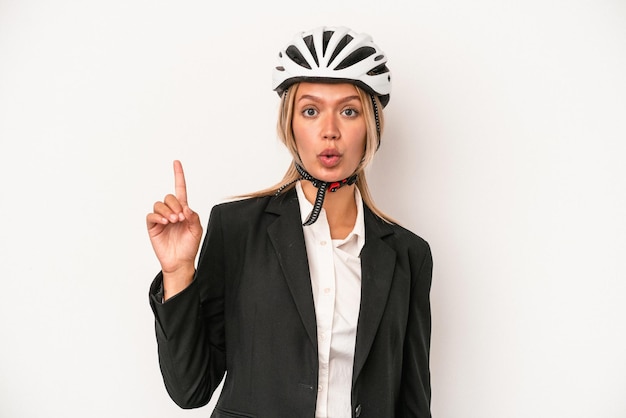 Giovane donna d'affari caucasica che indossa un casco da bici isolato su sfondo bianco con qualche grande idea, concetto di creatività.