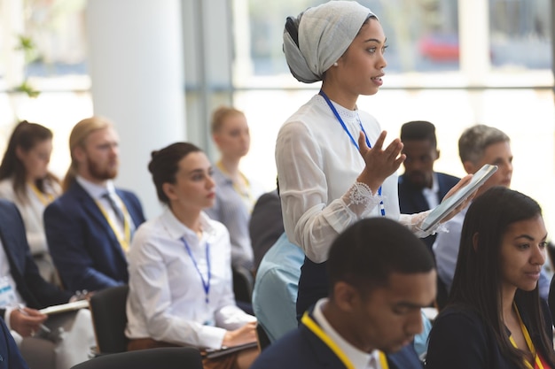 Giovane donna d'affari che fa domande durante il seminario