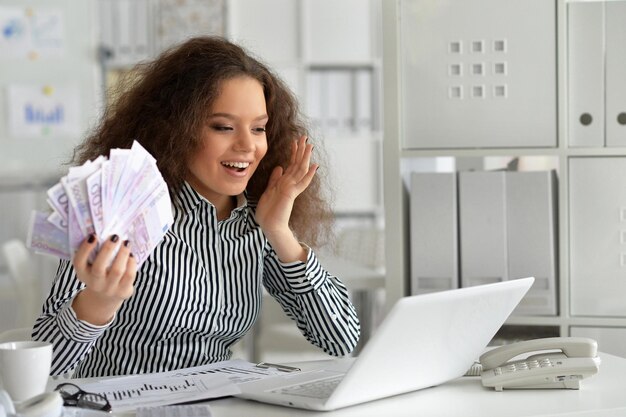 Giovane donna d'affari che lavora in ufficio, utilizzando il computer portatile
