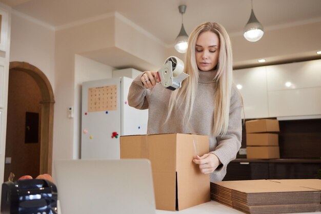 Giovane donna d'affari che registra una scatola di cartone nel trasferimento dell'ufficio e un nuovo concetto di business