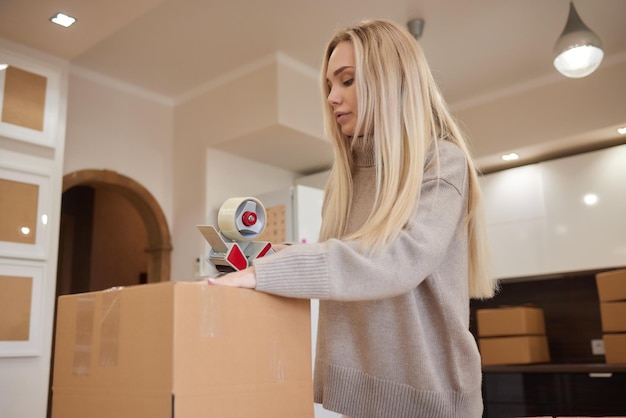 Giovane donna d'affari che registra una scatola di cartone nel trasferimento dell'ufficio e un nuovo concetto di business