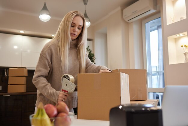 Giovane donna d'affari che registra una scatola di cartone nel trasferimento dell'ufficio e un nuovo concetto di business