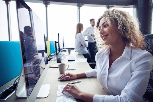 Giovane donna d'affari con computer in ufficio.