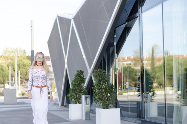Giovane donna d'affari di moda che cammina con gli occhiali da sole per strada
