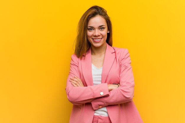 Giovane donna d'affari di moda che si sente sicura, incrociando le braccia con determinazione.