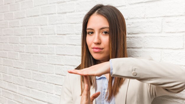 Giovane donna d'affari facendo un gesto di timeout