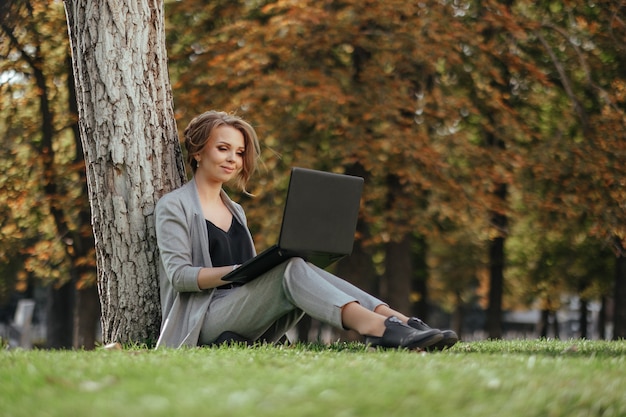 Giovane donna d'affari felice con il computer portatile