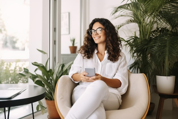 Giovane donna d'affari latina che indossa occhiali e parla allo smartphone mentre si rilassa in salotto