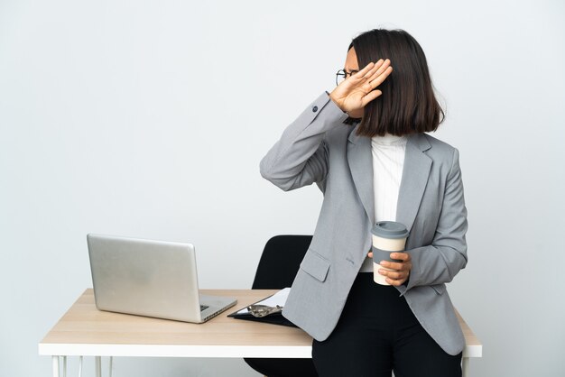 Giovane donna d'affari latina che lavora in un ufficio isolato su sfondo bianco che allunga le mani nervose in avanti