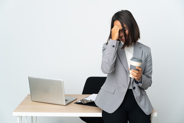 Giovane donna d'affari latino che lavora in un ufficio isolato su bianco ridendo