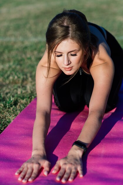 Giovane donna da sola allo stadio che fa yoga