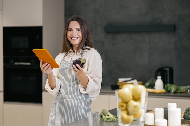 Giovane donna dai capelli lunghi che pensa di cucinare qualcosa per pranzo