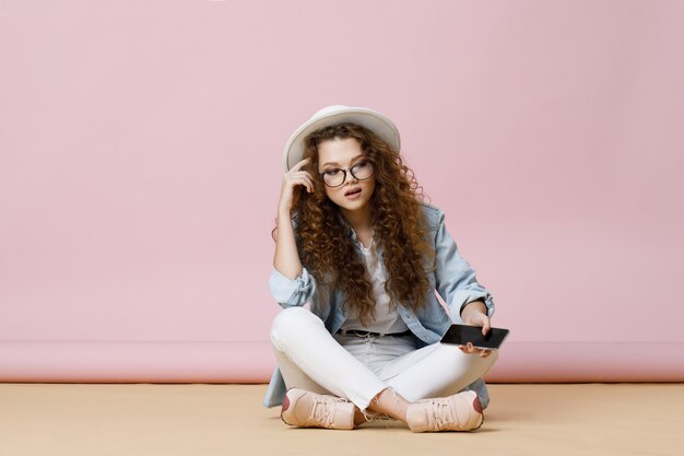 giovane donna dai capelli ricci con smartphone