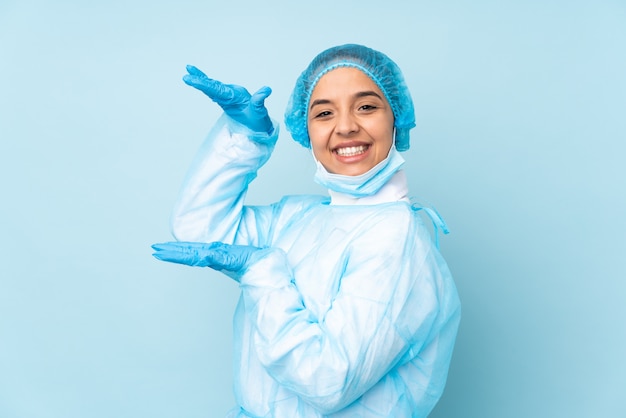 Giovane donna del chirurgo nel copyspace uniforme della tenuta blu per inserire un annuncio