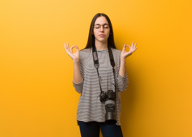 Giovane donna del fotografo che esegue yoga