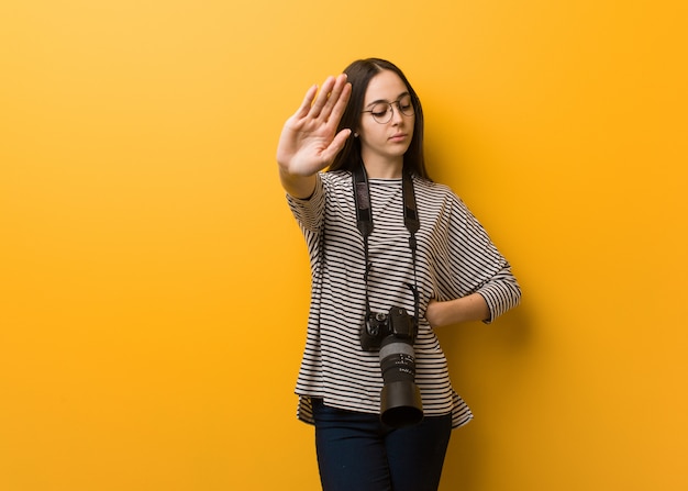 Giovane donna del fotografo che mette la mano nella parte anteriore