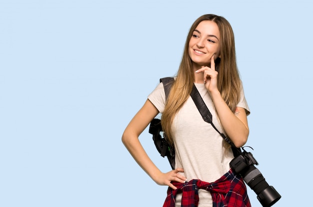 Giovane donna del fotografo che pensa un'idea mentre osservando in su