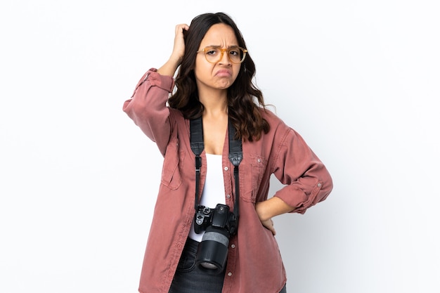 Giovane donna del fotografo sopra fondo bianco isolato che ha dubbi