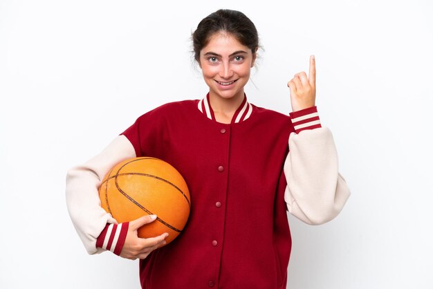 Giovane donna del giocatore di pallacanestro isolata su fondo bianco che indica una grande idea