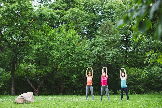 Giovane donna del gruppo che fa yoga all'aperto