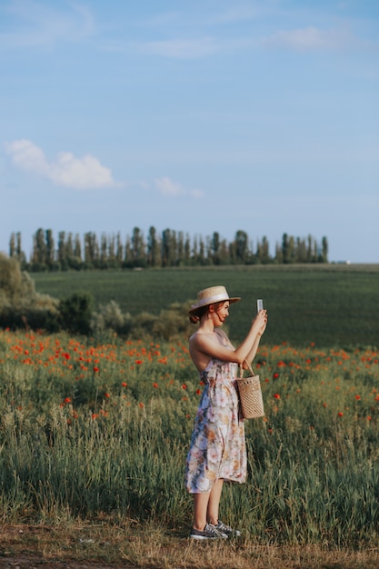 Giovane donna delicata che si distende nel raggio luminoso di tramonto. Ritratto integrale nel giacimento di fiore