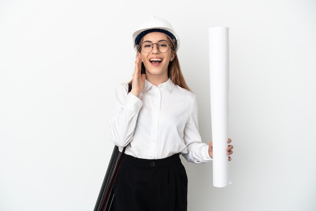 Giovane donna dell'architetto con il casco e che tiene i modelli isolati su fondo bianco che grida con la bocca spalancata