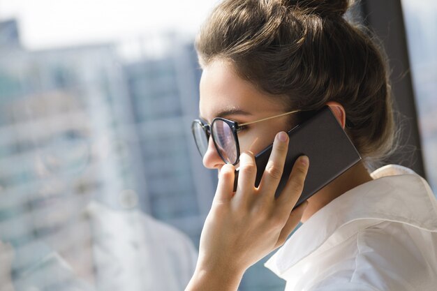 Giovane donna di affari che utilizza smartphone nel suo ufficio