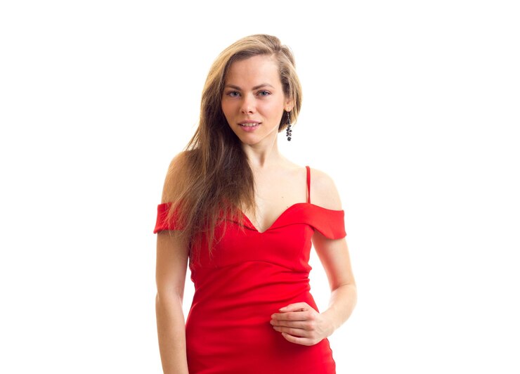 Foto giovane donna di bell'aspetto con lunghi capelli castani in abito rosso succinto su sfondo bianco in studio