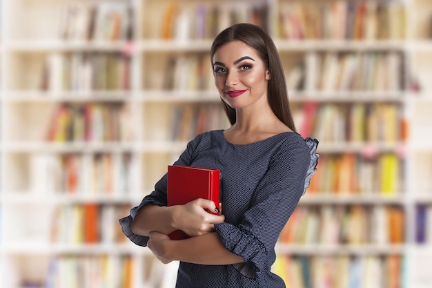 Giovane donna di bellezza con i libri in biblioteca